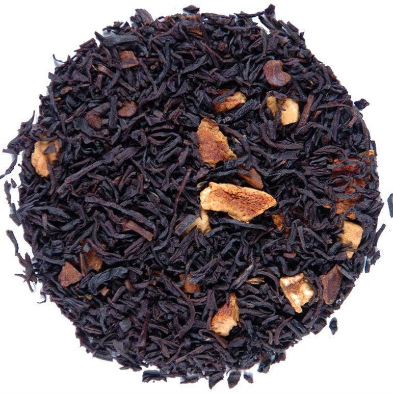 A circular pile of loose-leaf tea blend on a plain white background. The tea consists of very dark brown to near-black dried leaves with scattered light tan dried fruit pieces.