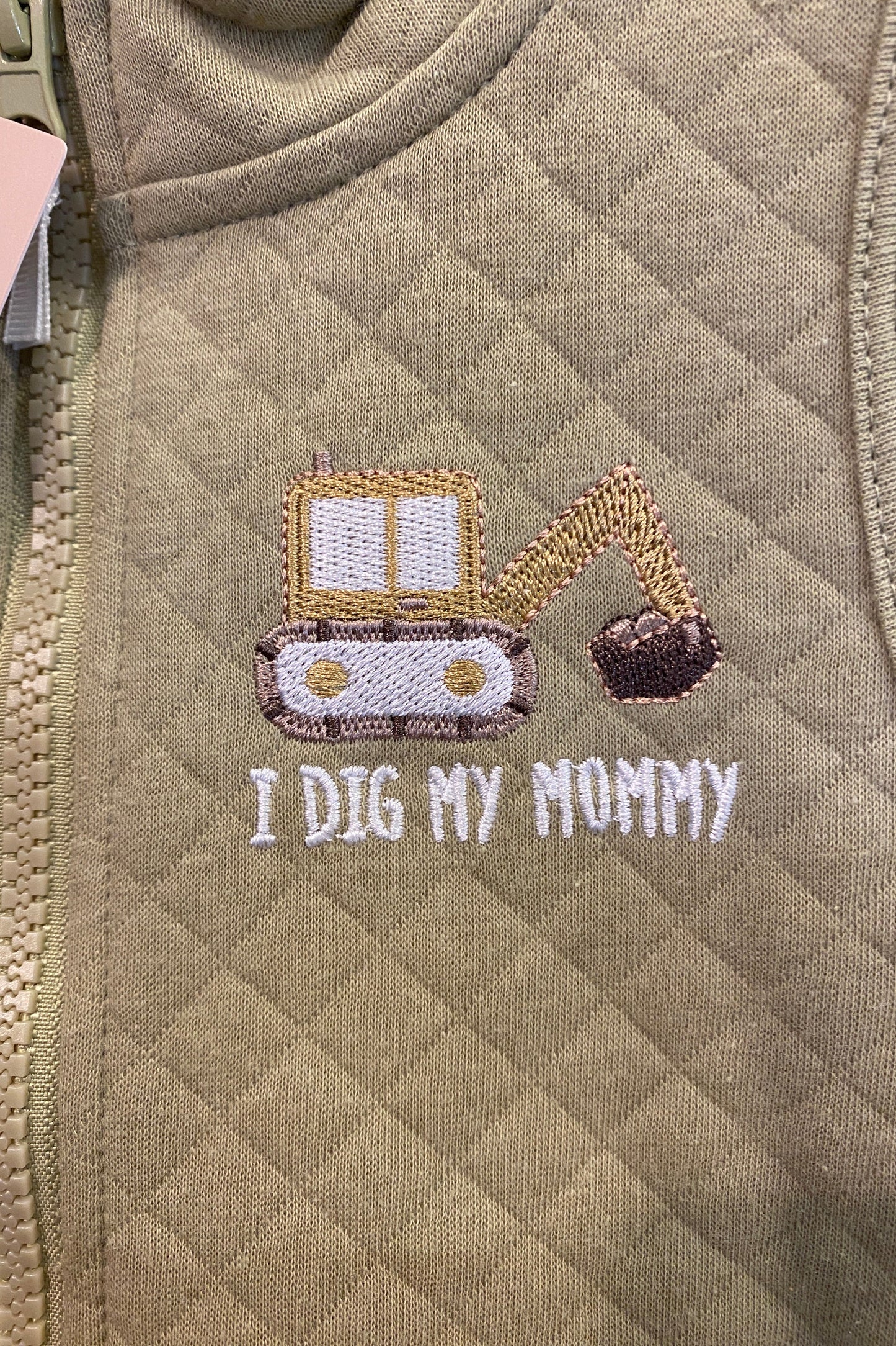 Khaki fabric with embroidered design and text 'I Dig My Mommy'