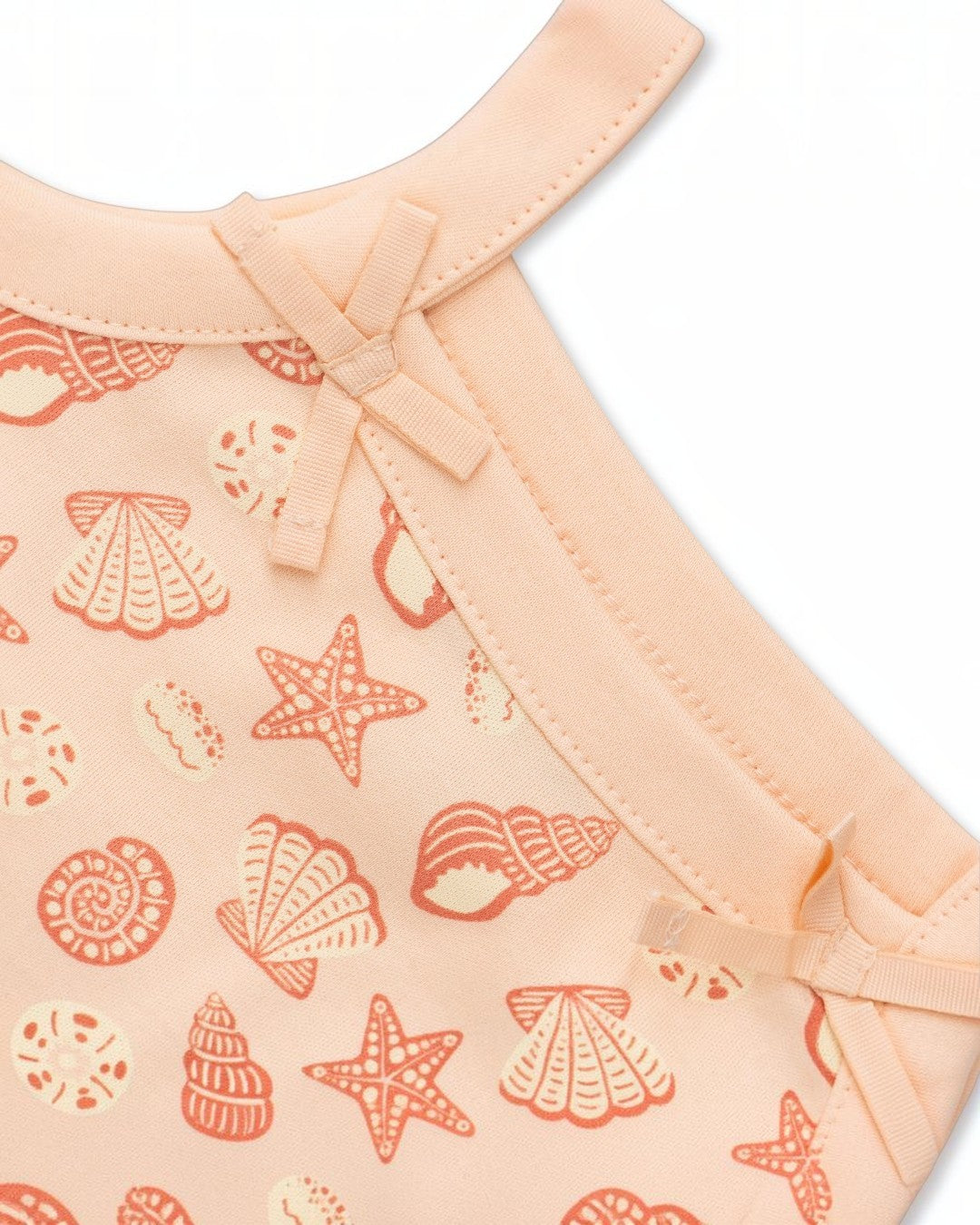 Baby outfit with shell pattern on a peach background