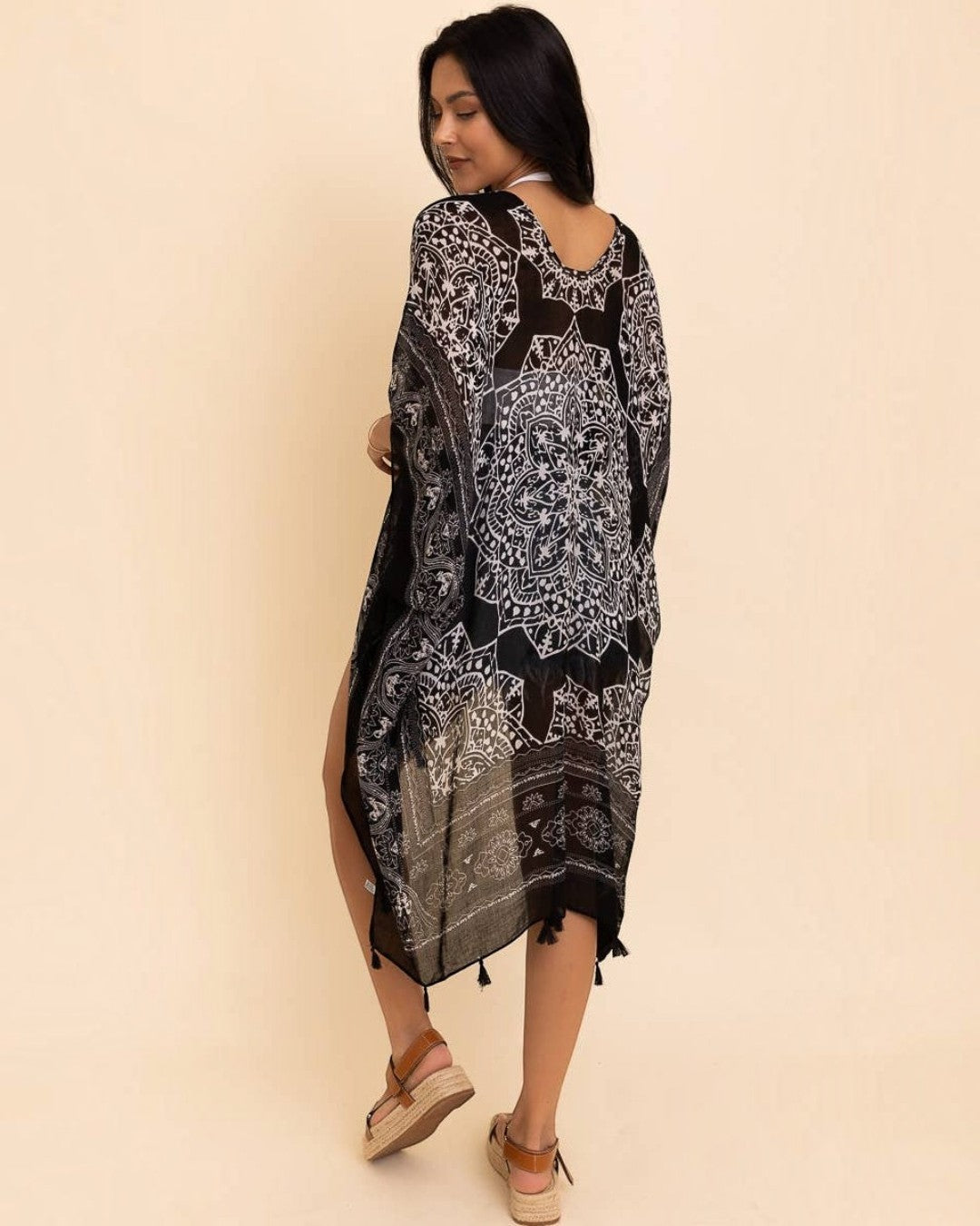 Woman wearing a black and white patterned dress on a beige background