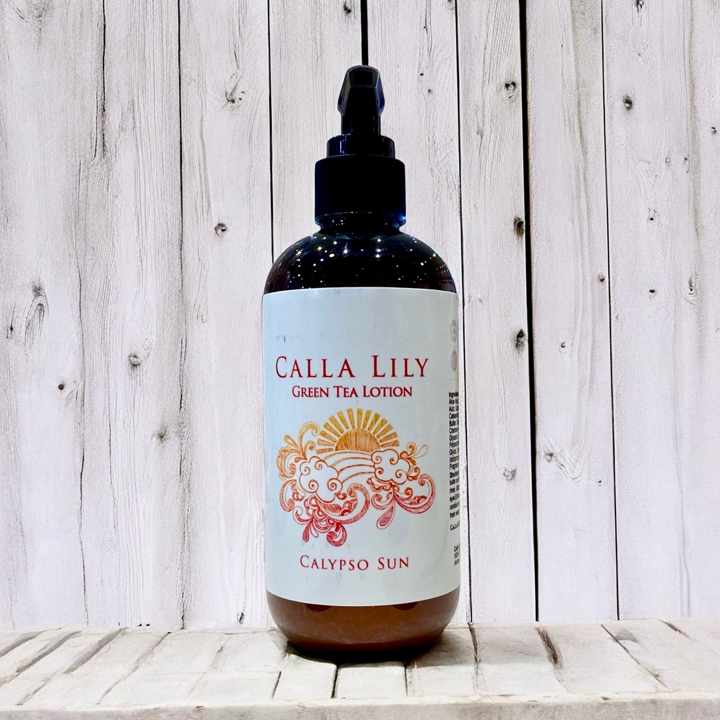 Bottle of Calla Lily Green Tea Lotion on a wooden surface with a light wood panel background