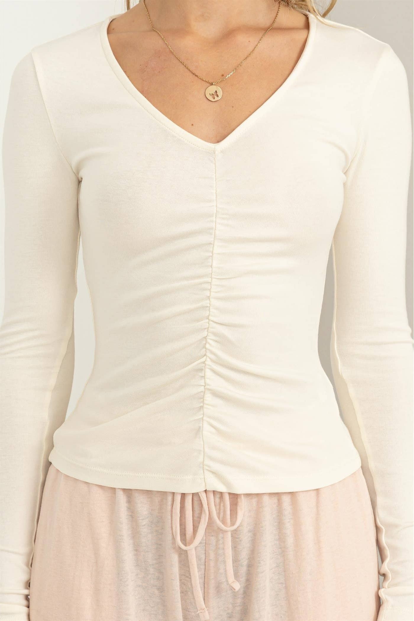 White long-sleeve top worn by a person on a plain background