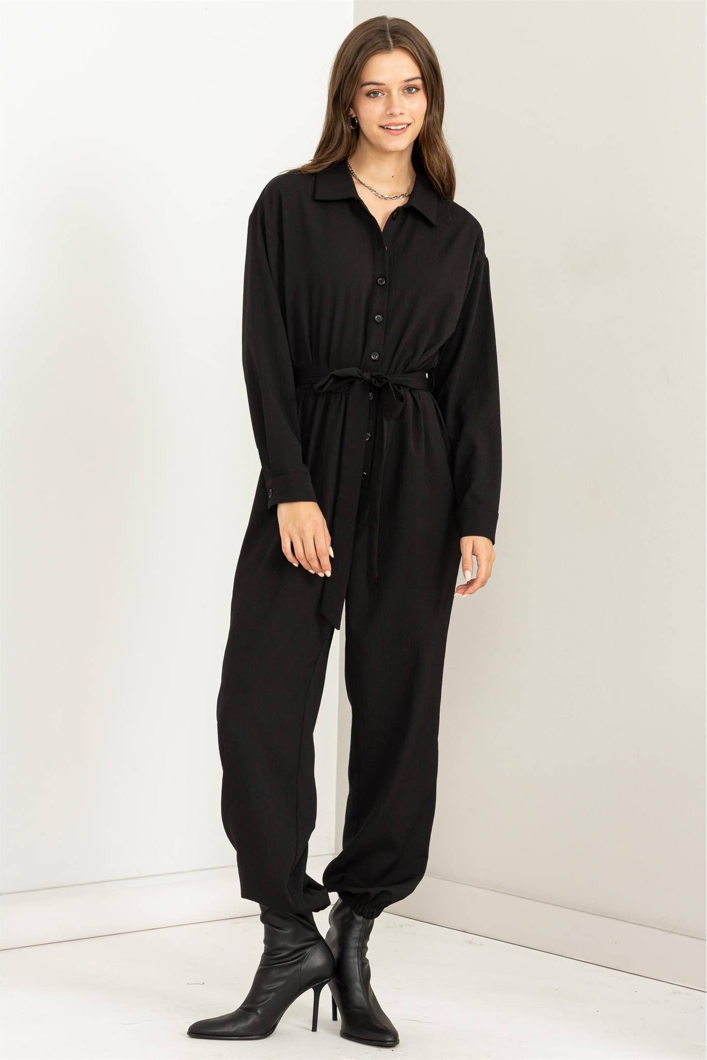 Woman wearing a black jumpsuit on a white background