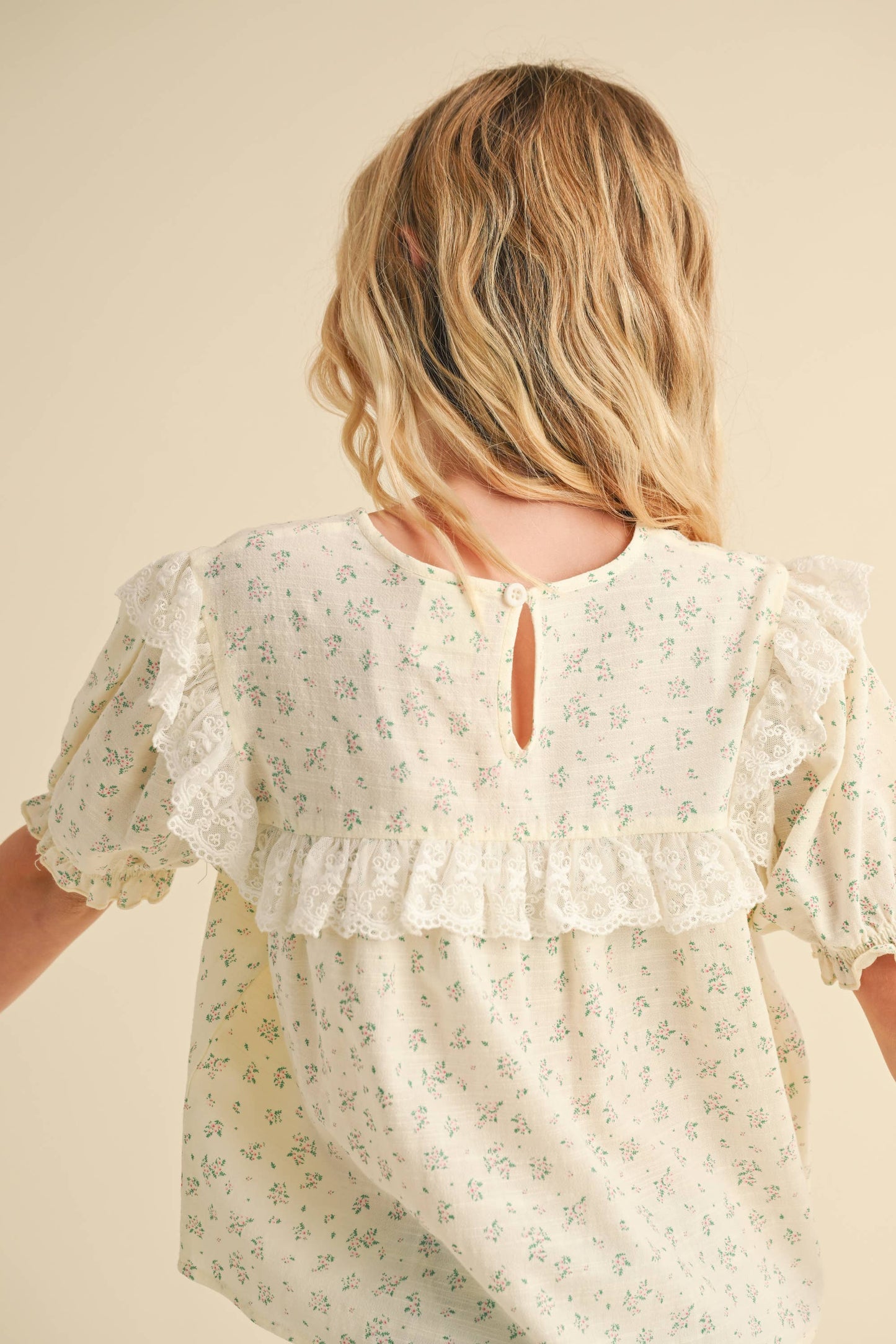 Woman wearing a floral blouse with a neutral background