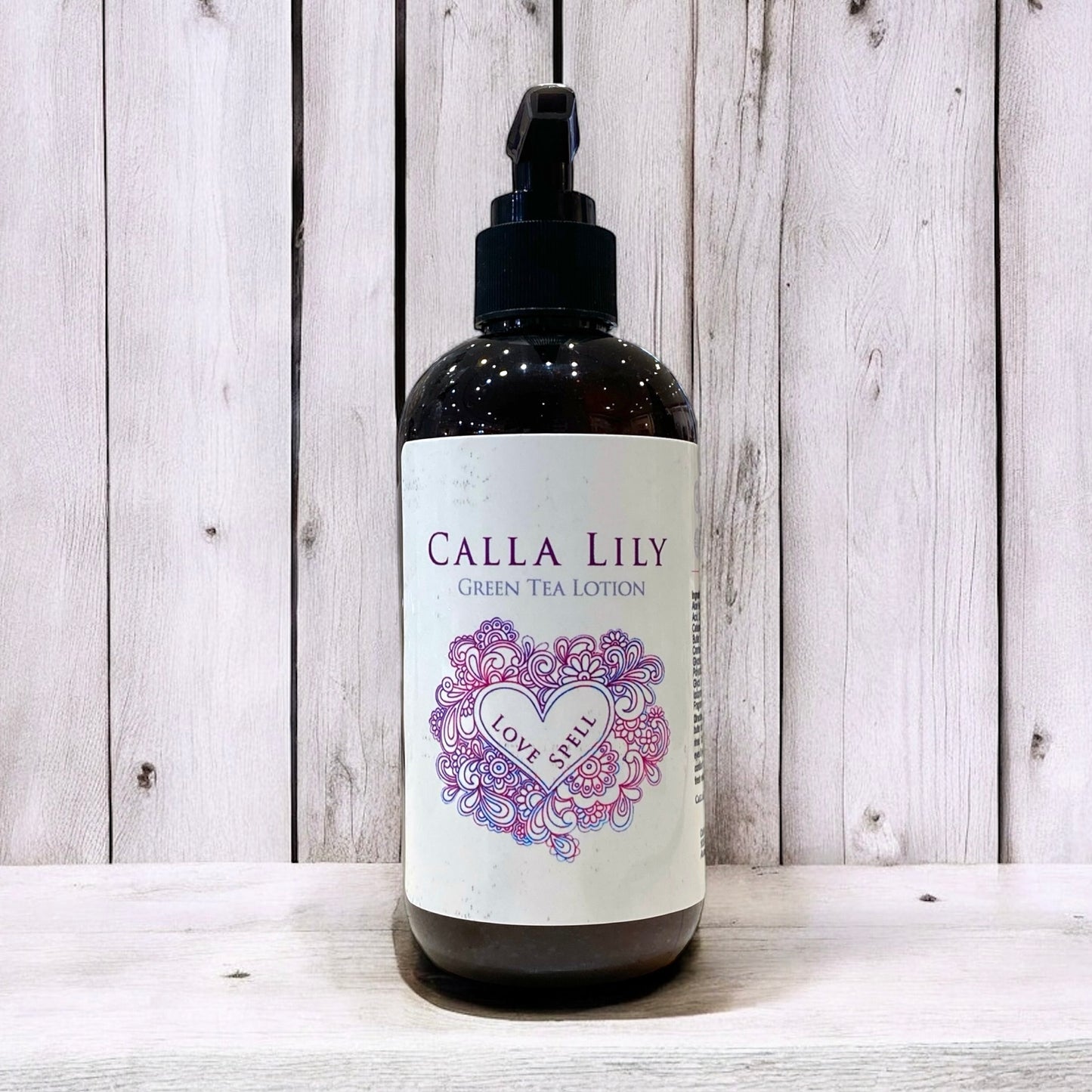 Bottle of Calla Lily Green Tea Lotion with decorative label on a wooden background