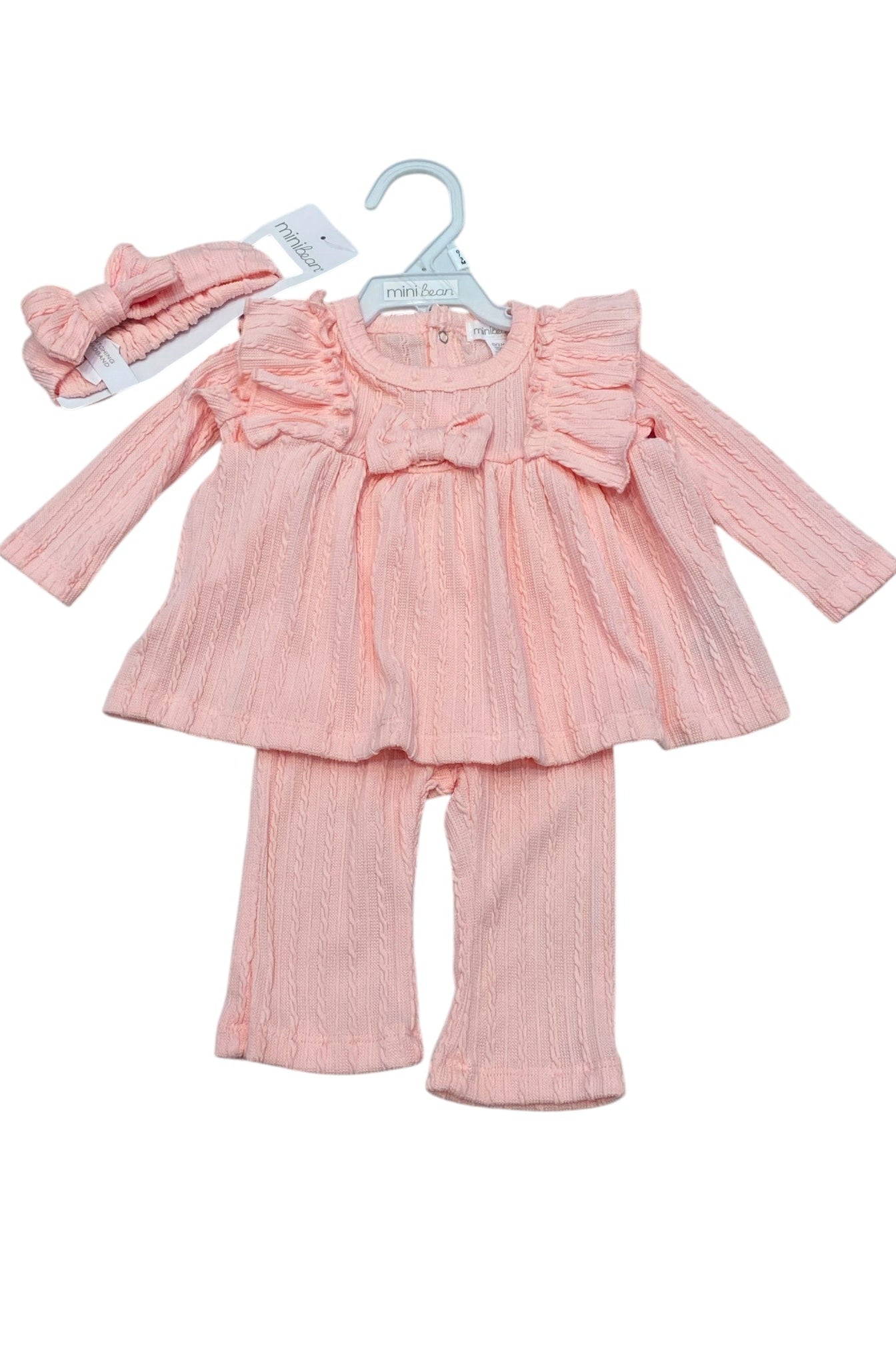 Pink baby outfit with top, pants, and headband on a white background