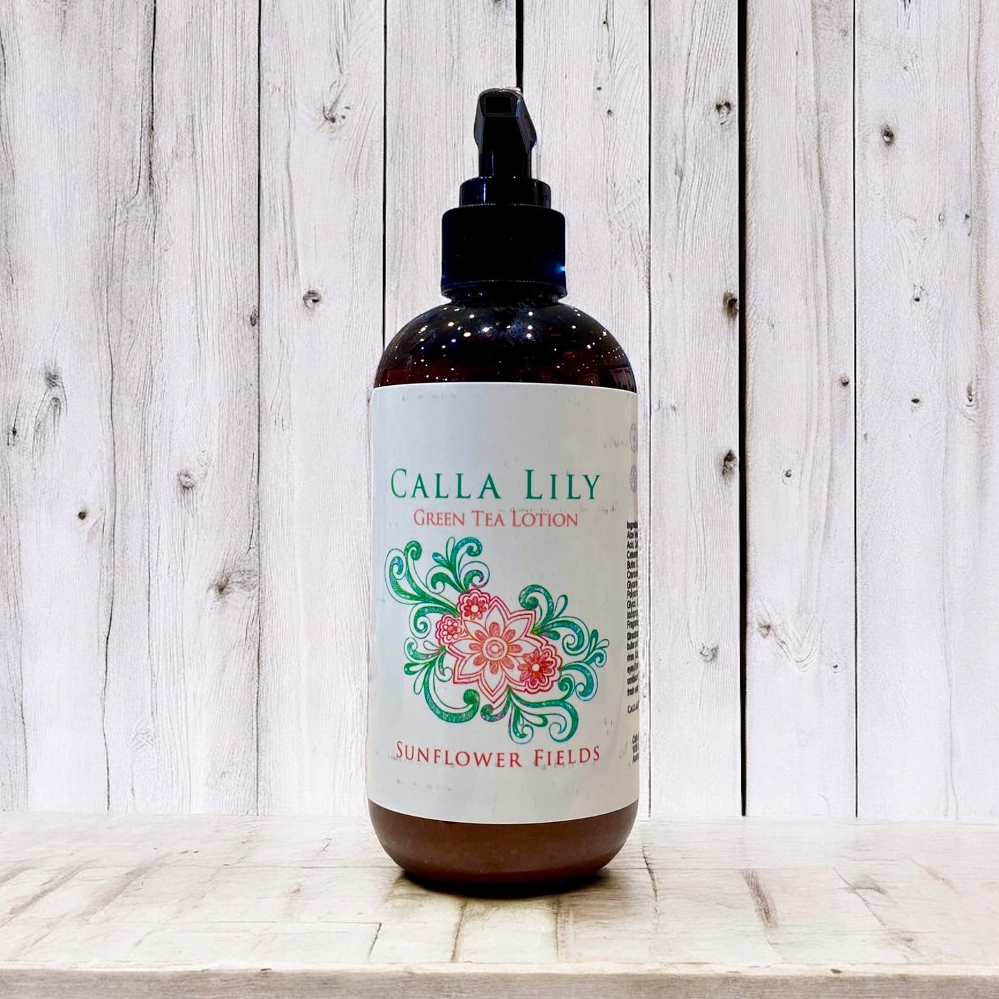 Bottle of Calla Lily Green Tea Lotion with decorative label on a wooden surface