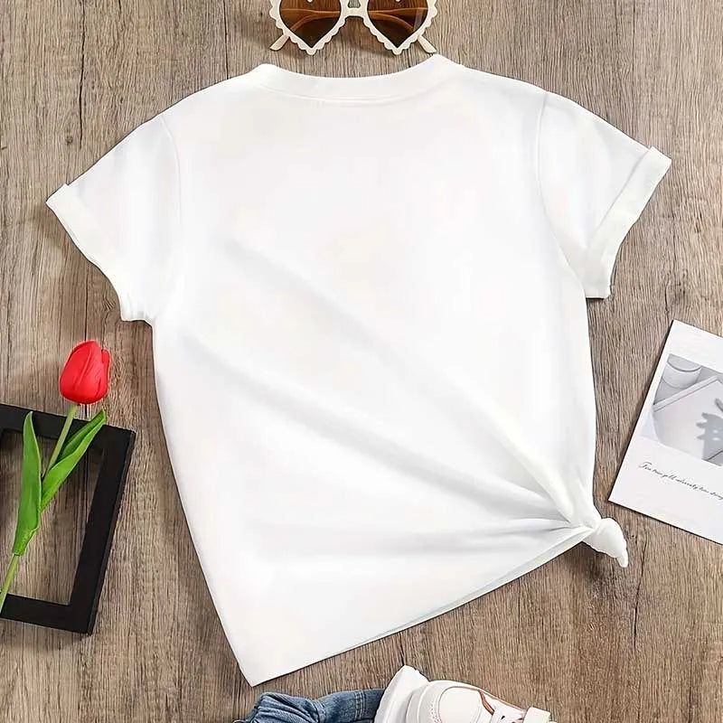 White t-shirt on a wooden surface with a red tulip, sunglasses, and a photo frame.
