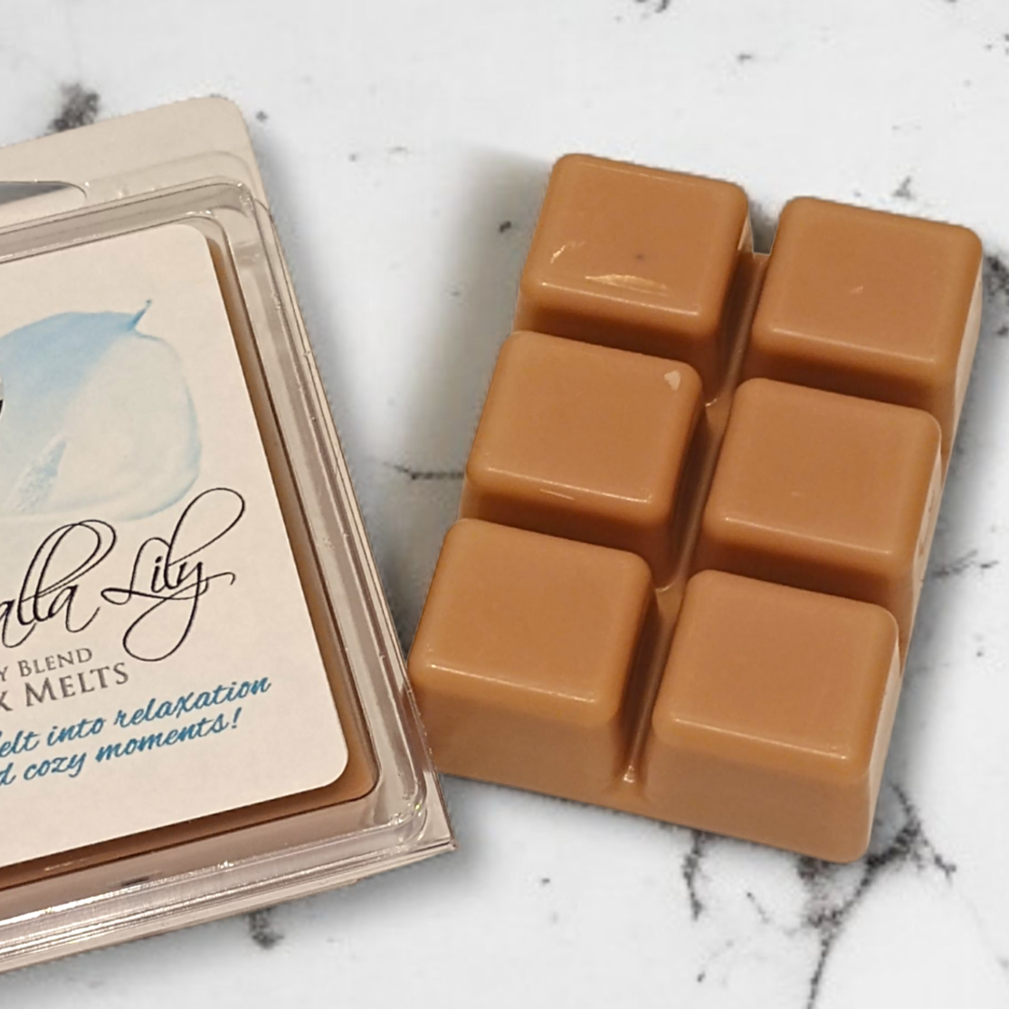 Caramel-colored wax melts in a clear plastic packaging on a marble surface