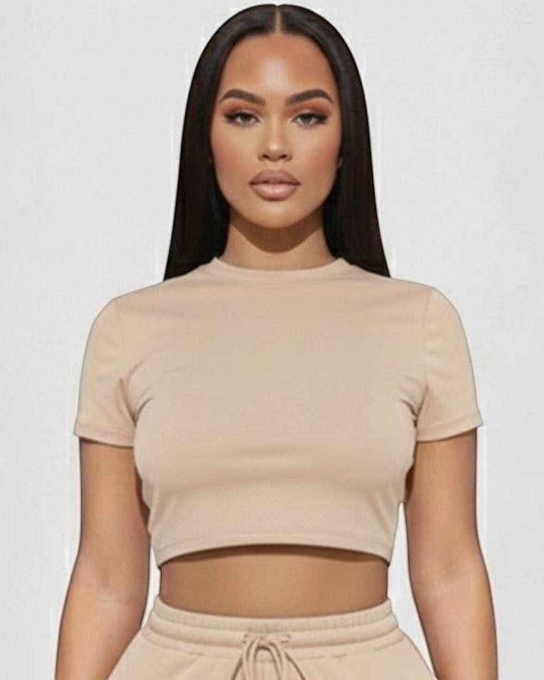 Woman wearing a beige crop top and shorts set on a white background