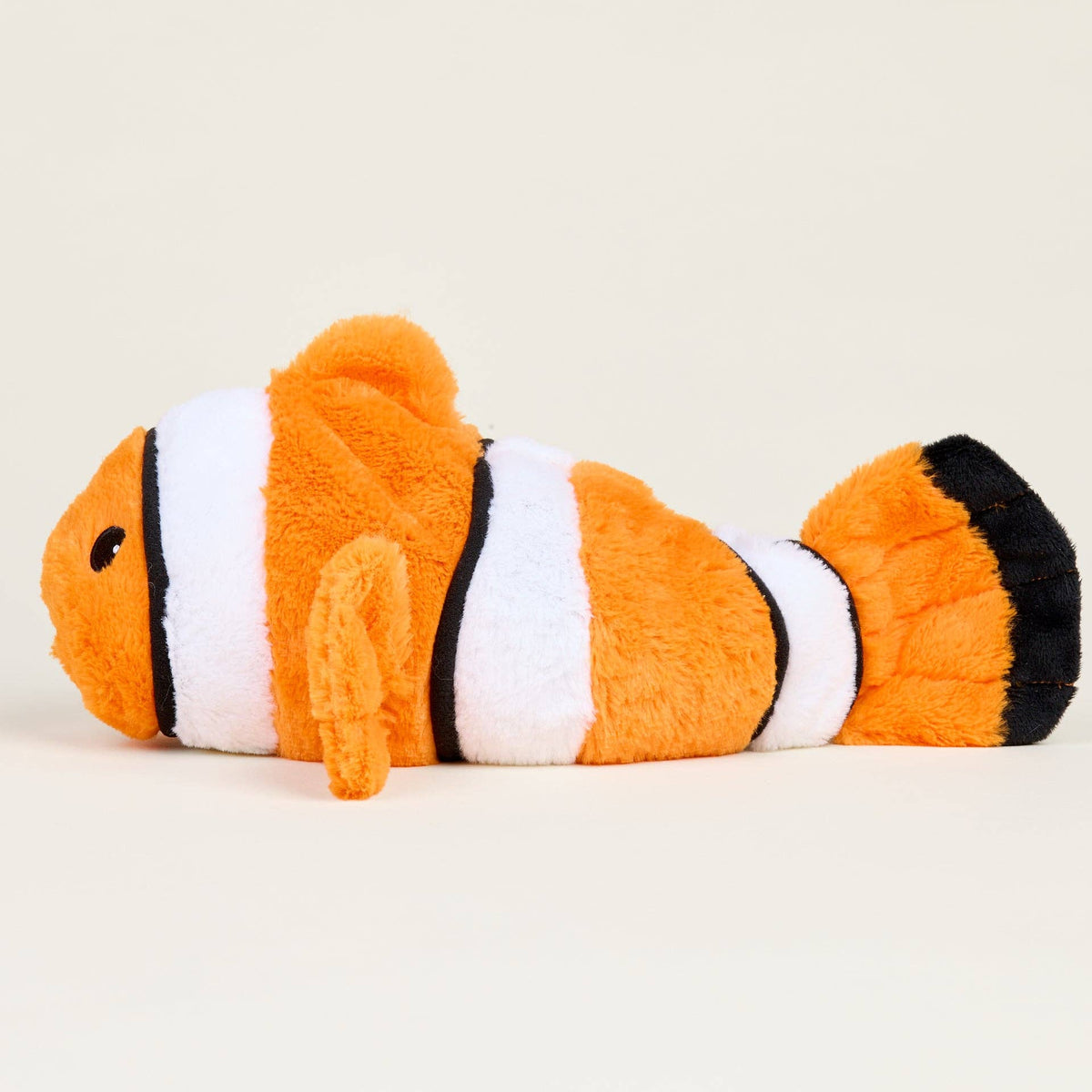 Plush toy shaped like a clownfish on a beige background