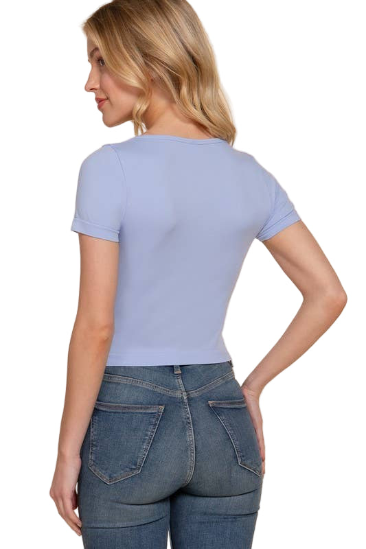 Woman wearing a light blue t-shirt and jeans on a beige background