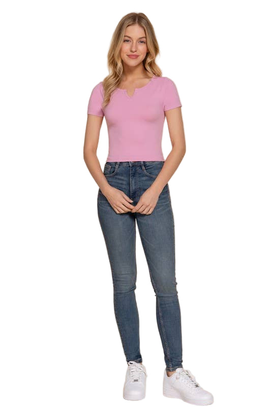 Woman wearing a pink top and blue jeans on a beige background