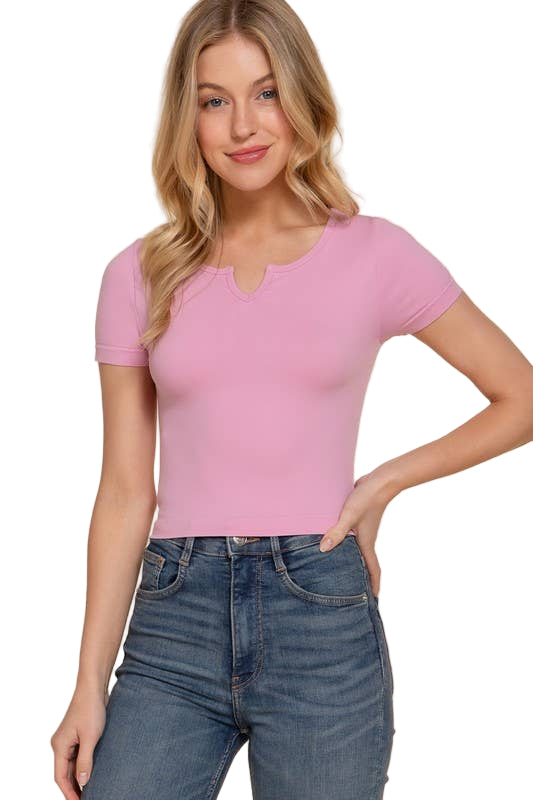 Woman wearing a pink top and blue jeans on a beige background