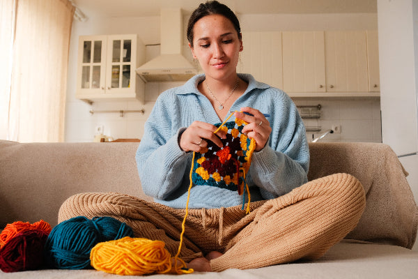 woman crocheting on couch crafty corner main image