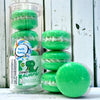 A stack and tube of green dino burps bath cookies against a wood background