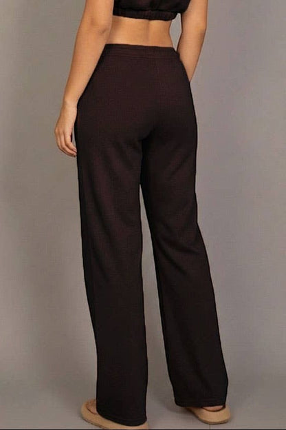 Woman wearing a brown outfit against a gray background