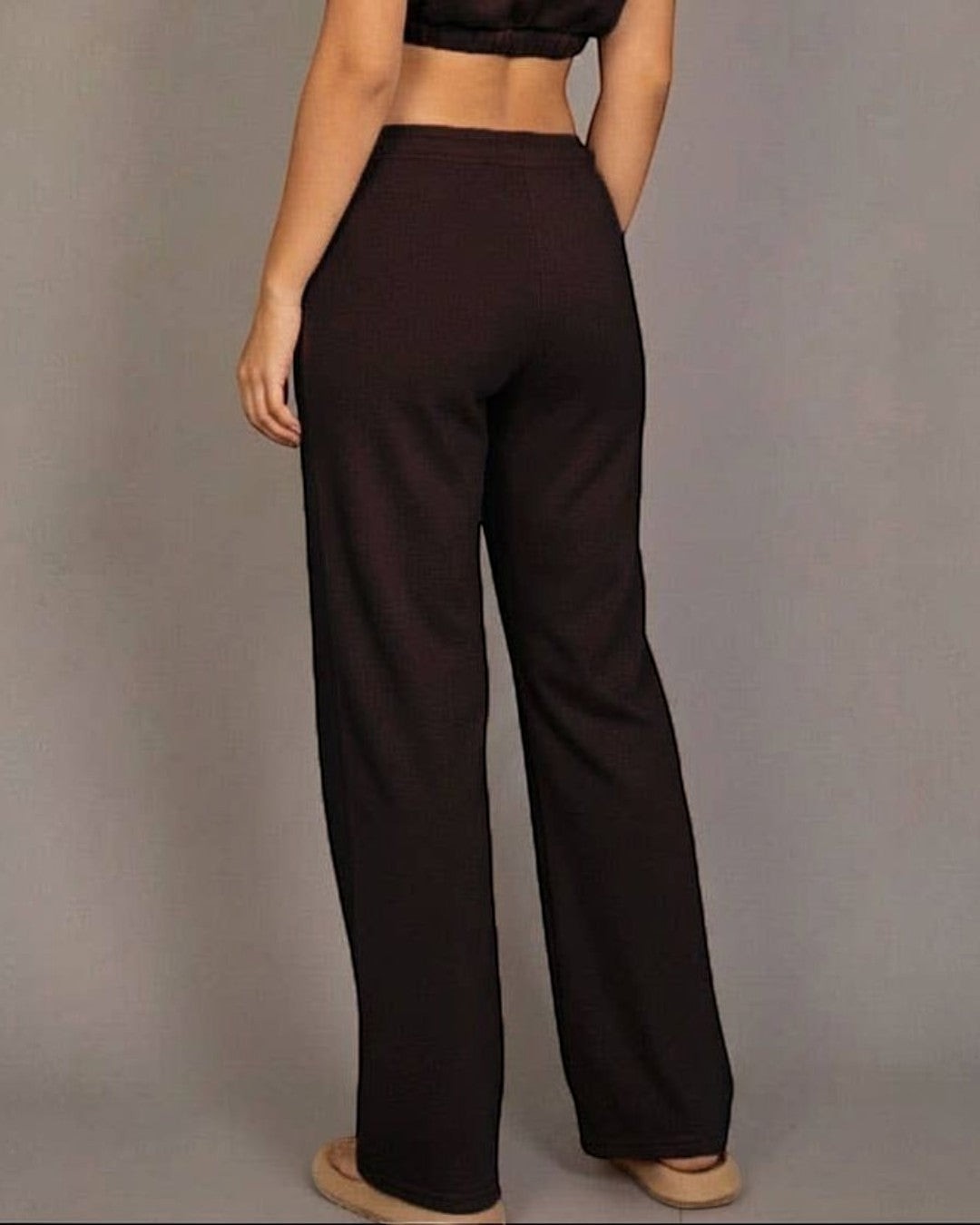 Woman wearing a brown outfit against a gray background