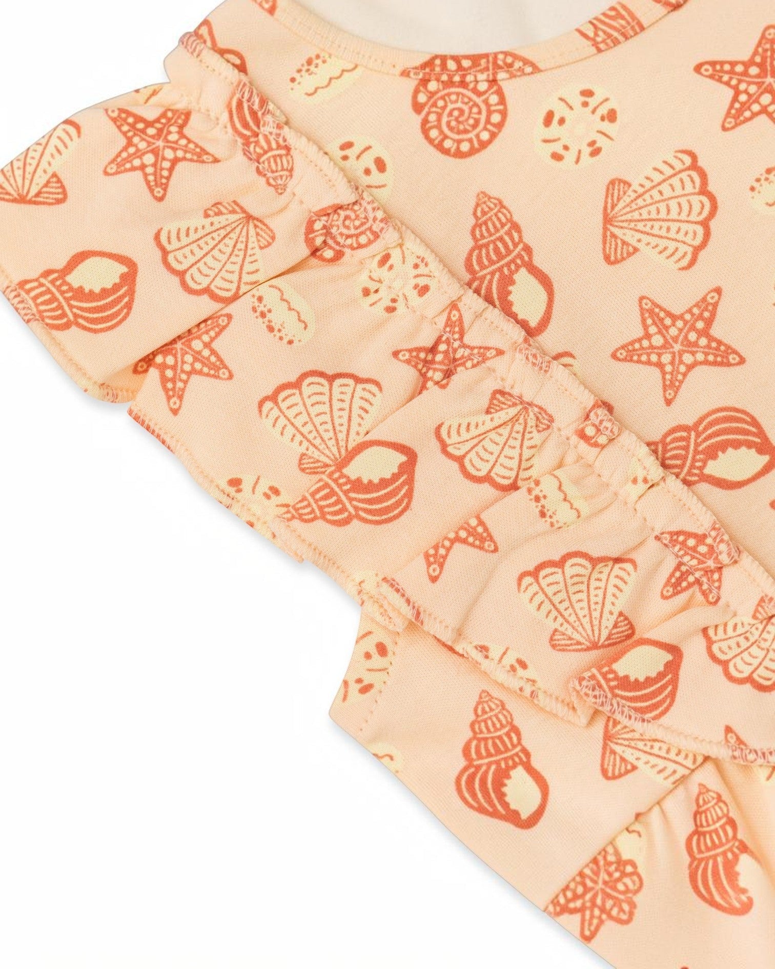 Quilted fabric with red shell and starfish pattern on a peach background