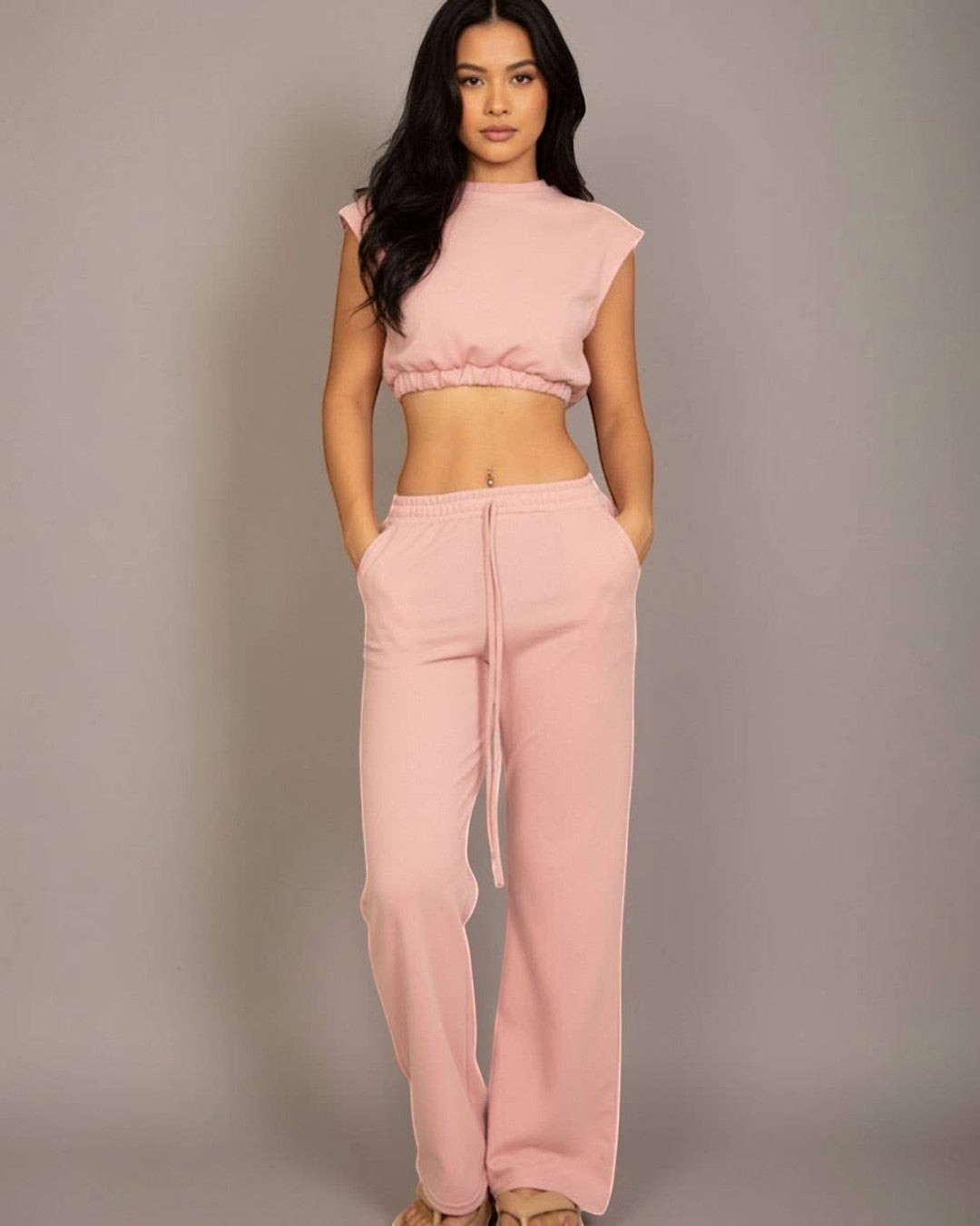 Woman wearing a pink outfit against a gray background
