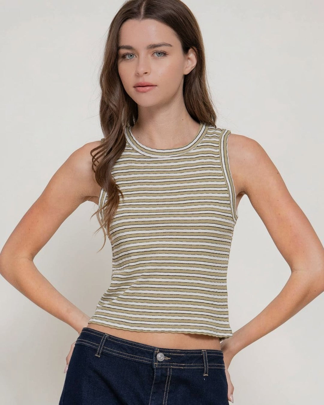 Woman wearing a striped tank top against a plain background