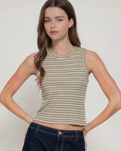 Woman wearing a striped tank top against a plain background