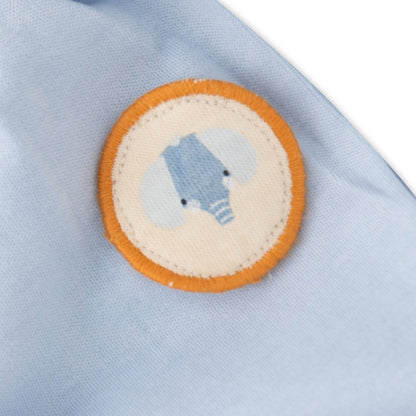 Close-up of a light blue fabric with a circular patch featuring a bear design.