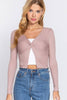Woman wearing a pink long-sleeve top with a white underlayer and blue jeans on a white background