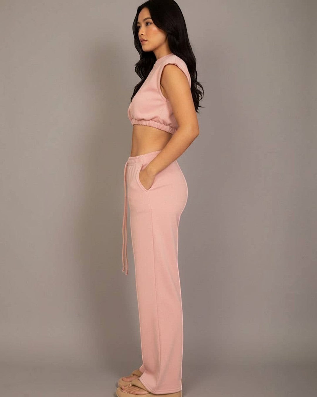 Woman wearing a pink outfit against a plain background
