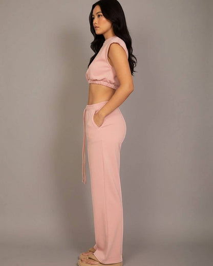 Woman wearing a pink outfit against a plain background