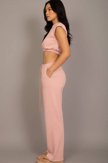 Woman wearing a pink outfit against a plain background