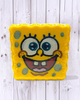 Calla Lily Cosmetics + CL kids Sponge Bob shaped yellow bath bomb with hand-painted details on a wood background