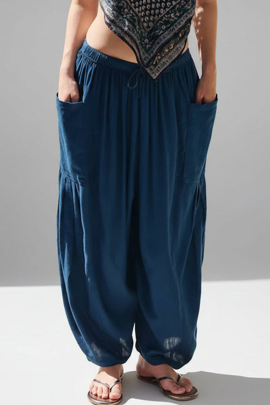 Person wearing blue harem pants by a pool