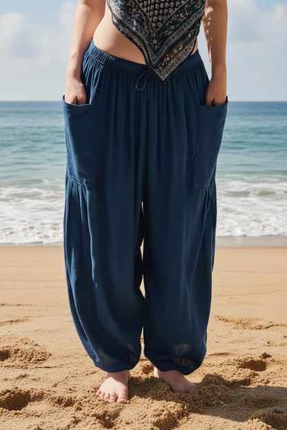 Person wearing blue harem pants by a pool