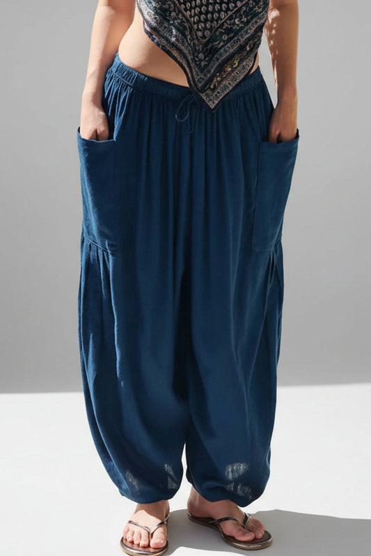 Person wearing blue harem pants by a pool