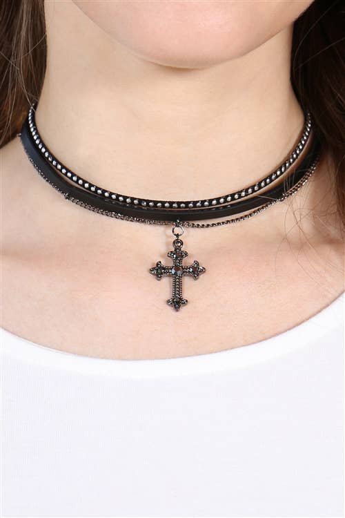 Necklace with a cross pendant worn by a person on a white background
