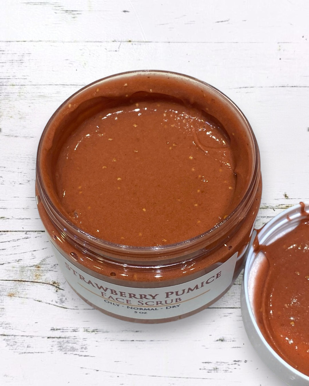 Calla Lily Cosmetics + CL kids Strawberry Pumice Facial Scrub in an open jar with a smooth, reddish-brown texture.