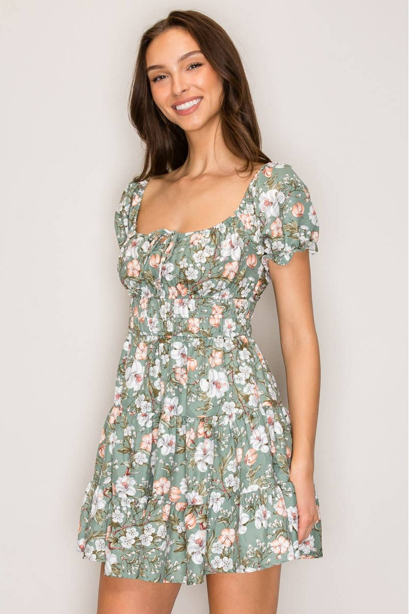 Woman wearing a floral dress against a plain background