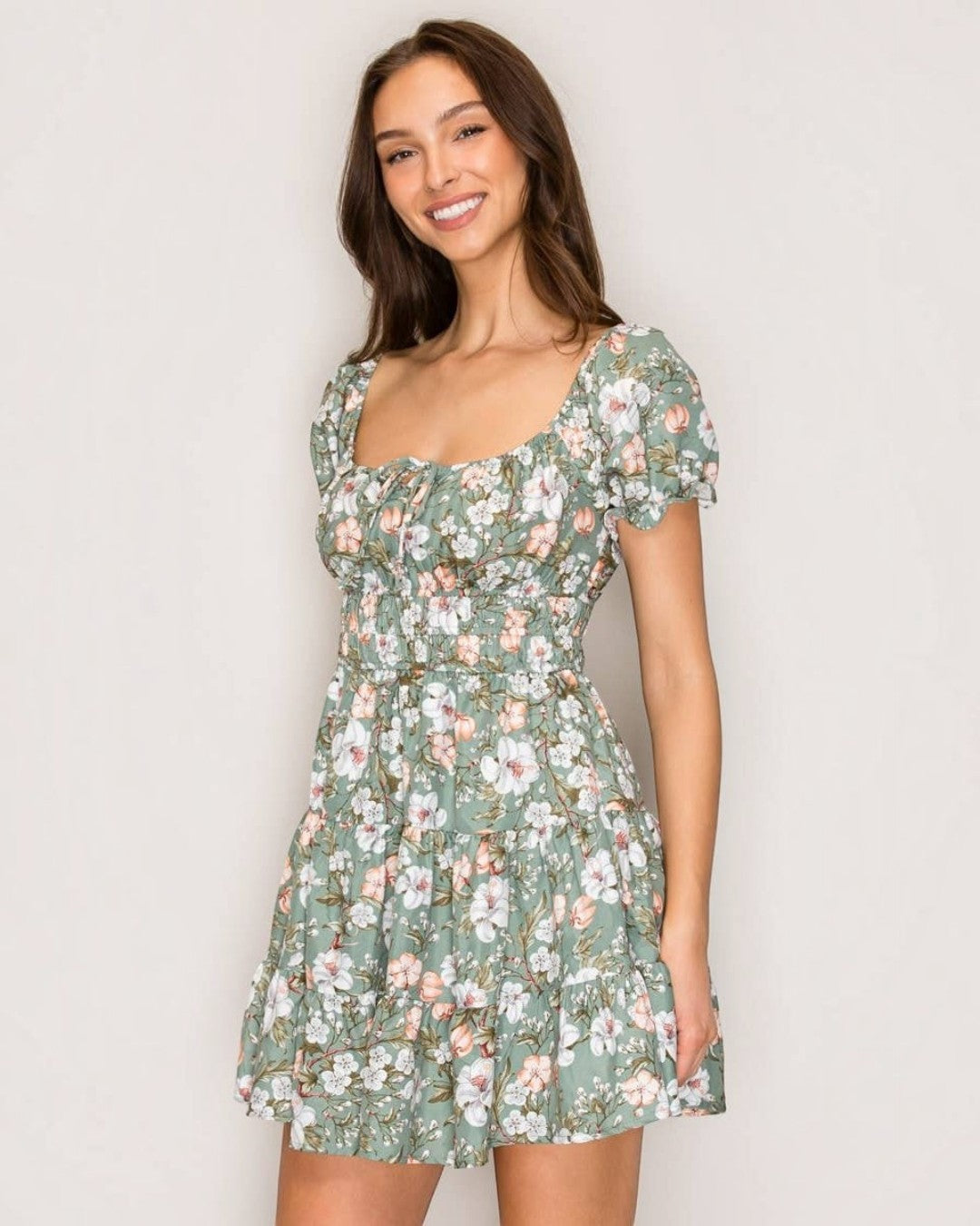 Woman wearing a floral dress against a plain background