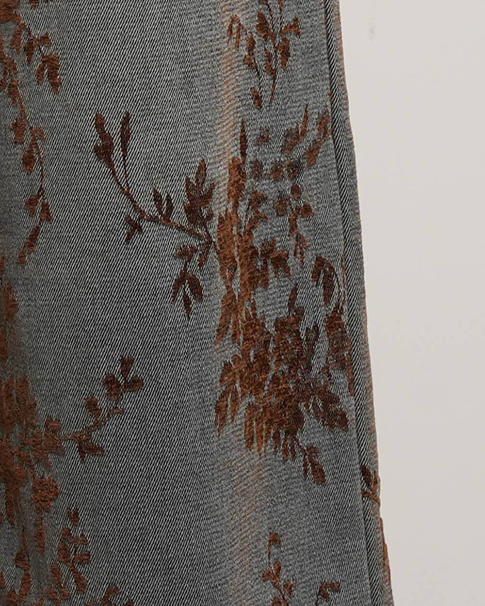 Gray fabric with brown floral embroidery on a white background