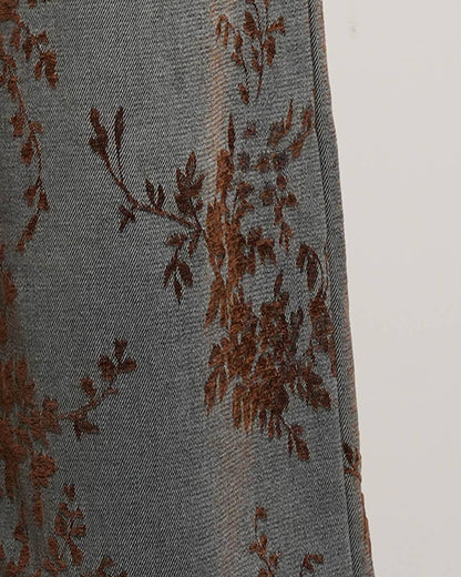 Gray fabric with brown floral embroidery on a white background
