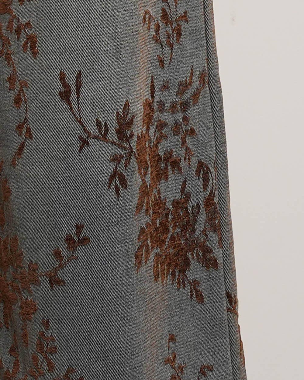 Gray fabric with brown floral embroidery on a white background