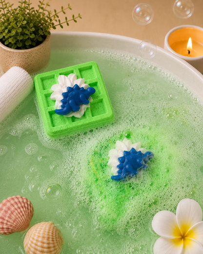 Soap mold with dinosaur design in a bubble bath with shells and a candle.