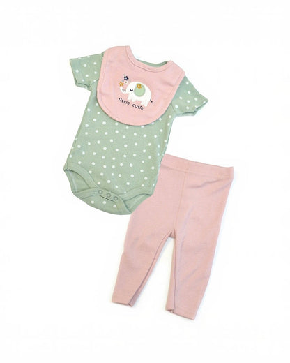 Baby outfit with green polka dot onesie, pink bib, and matching pants on a white background