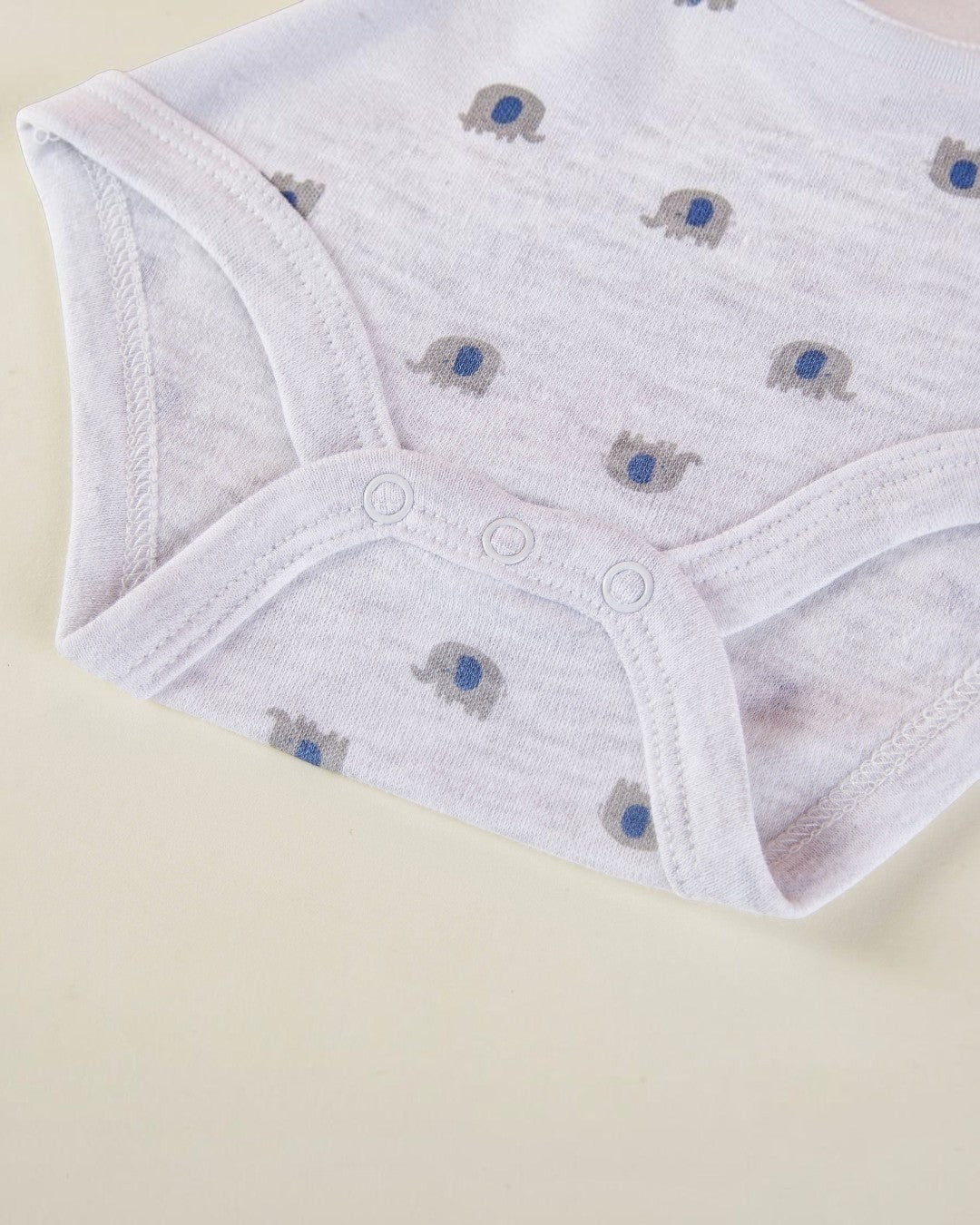 White baby pants with elephant pattern on a beige background