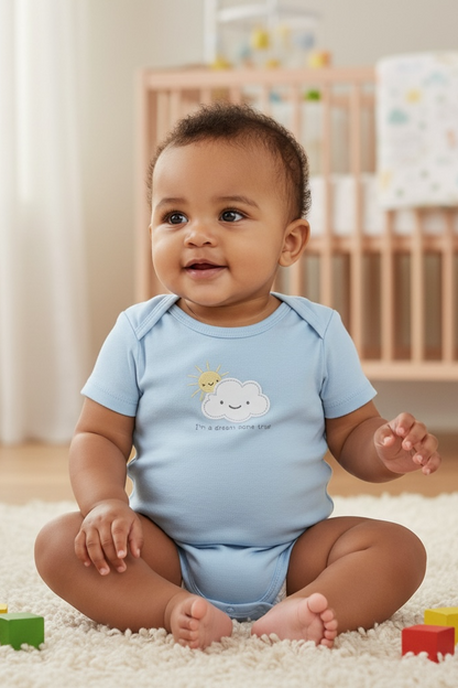 Baby sitting on a carpeted floor with colorful blocks, wearing a light blue onesie with a cloud design.