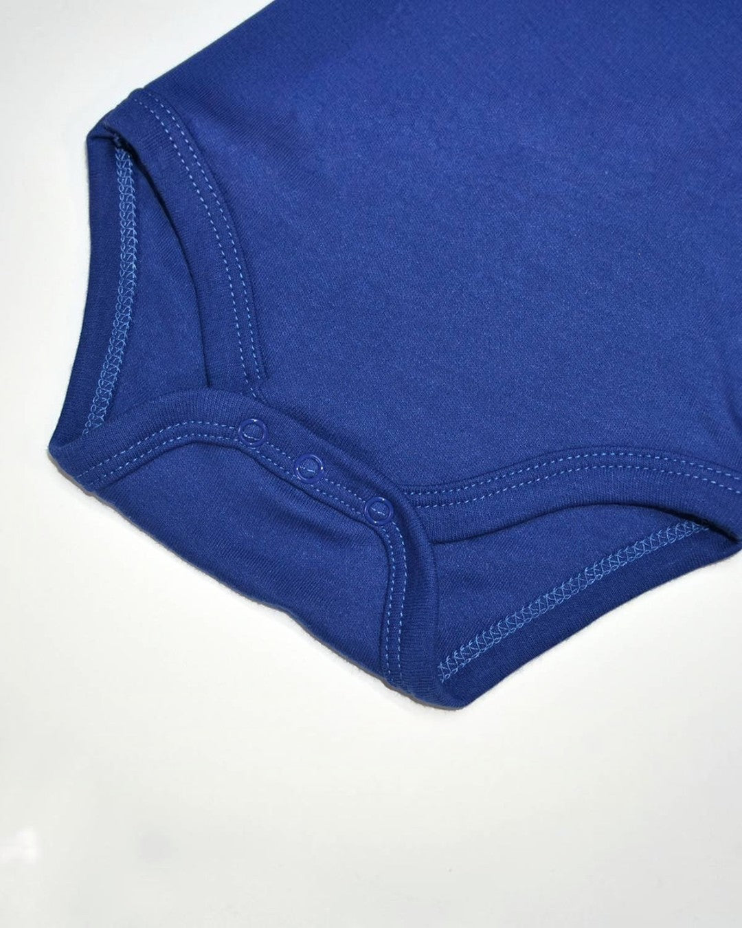 Close-up of a blue baby onesie on a white background