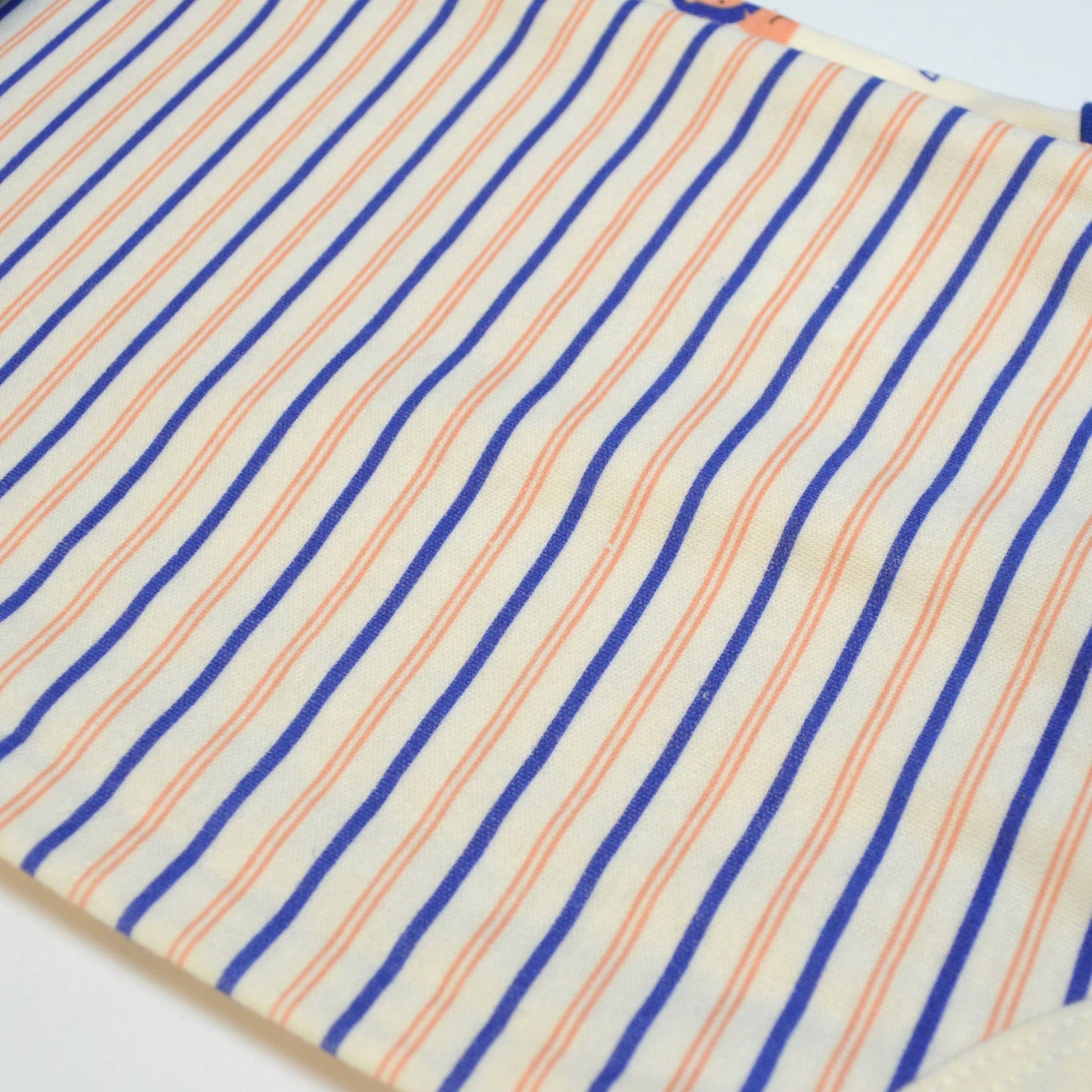 Close-up of fabric with blue and orange stripes on a white background