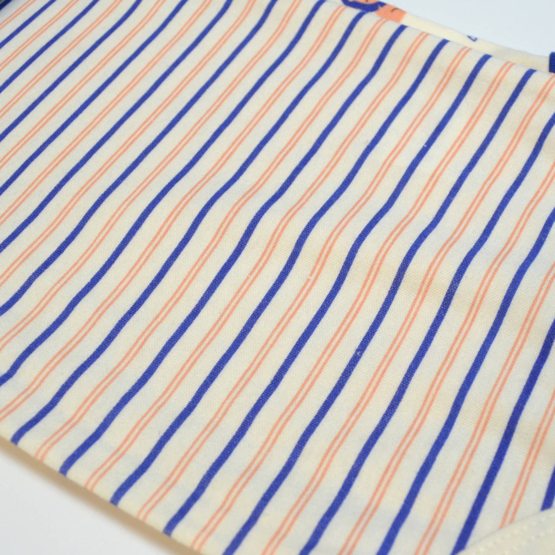 Close-up of fabric with blue and orange stripes on a white background