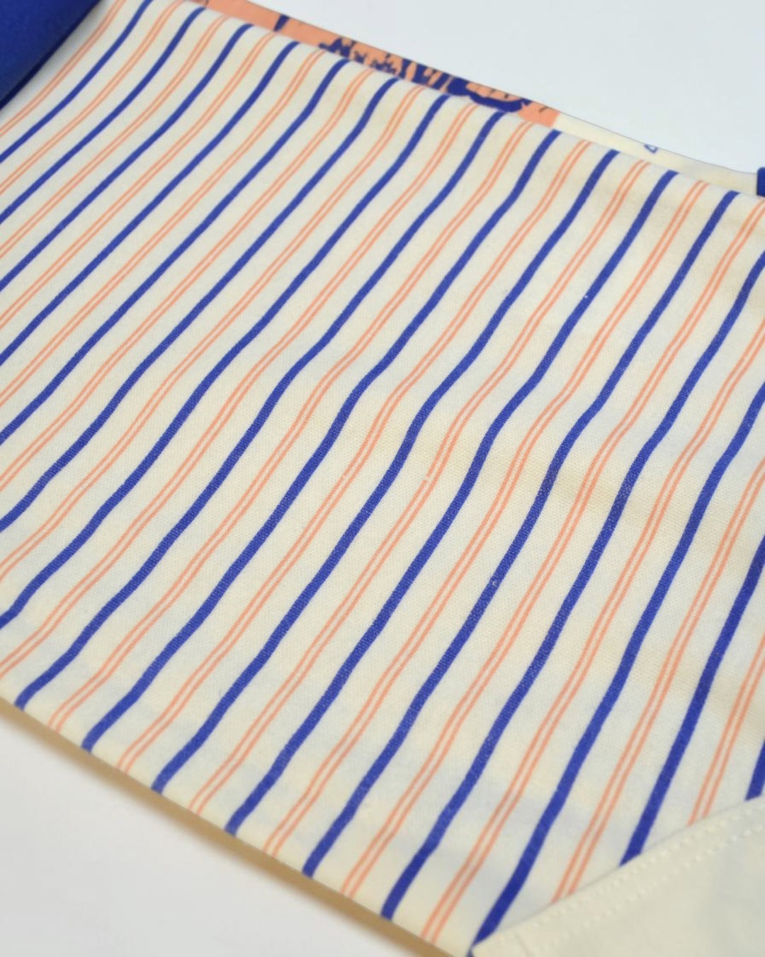 Close-up of fabric with blue and orange stripes on a white background